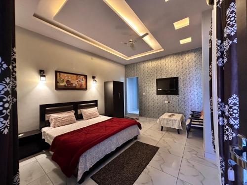 a bedroom with a bed and a tv on the ceiling at Hotel Tulsi in Haldwāni