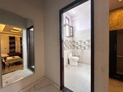 a bathroom with a toilet and a mirror at Hotel Tulsi in Haldwāni