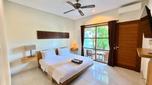 a bedroom with a bed and a window at Moonlight Sanur in Sanur
