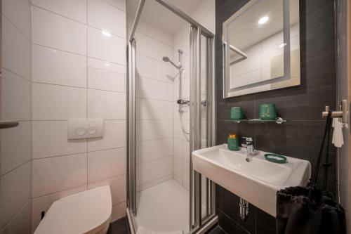 a bathroom with a sink and a shower and a toilet at Hotel Haus Hohne in Hohne