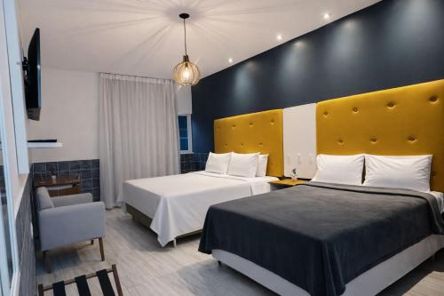 a hotel room with two beds and a chair at Hotel Summer Beach Paripueira Maceió in Paripueira