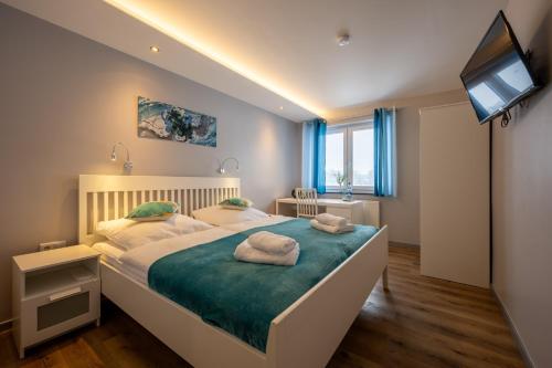 a bedroom with a large bed with towels on it at Hotel Haus Hohne in Hohne