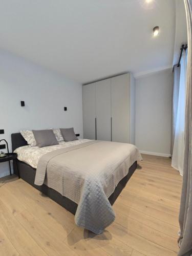 a bedroom with a large bed in a white room at Haustory Deluxe Apartment in Klaipėda