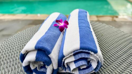 a pair of blue and white towels with a flower on them at Moonlight Sanur in Sanur