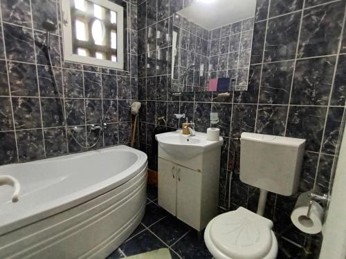a bathroom with a tub and a toilet and a sink at Apartament Magic Petroșani in Petroşani