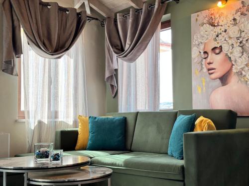 a living room with a green couch and a painting at Bloom Garden 3 in Mytilene