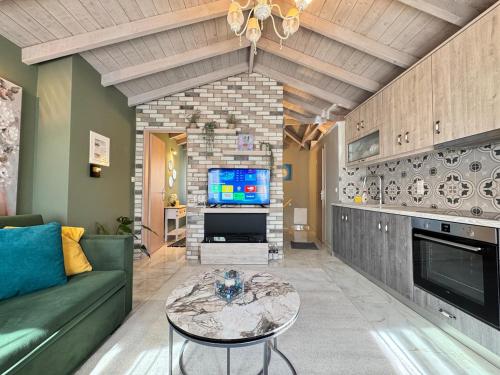 a living room with a couch and a table and a tv at Bloom Garden 3 in Mytilene