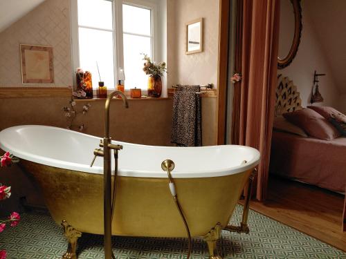 a bath tub in a bathroom with a bedroom at Le Banellou in Quimper