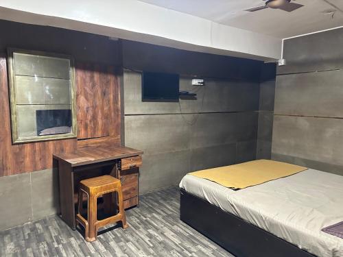 a bedroom with a bed and a desk and a window at DIAMOND PALACE Kalasipalya in Bangalore