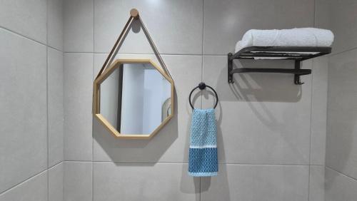 a mirror and a towel rack in a bathroom at Apartamento Maré Alta in Tamandaré