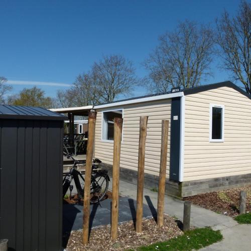 a small house with a bike parked next to it at Chalet B2 900 m vom Strand in Koudekerke