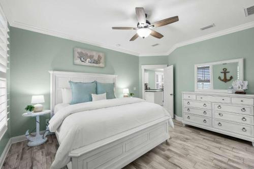 a bedroom with a white bed and a ceiling fan at Sunset Nirvana in Panama City Beach