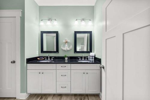a bathroom with two sinks and two mirrors at Sunset Nirvana in Panama City Beach