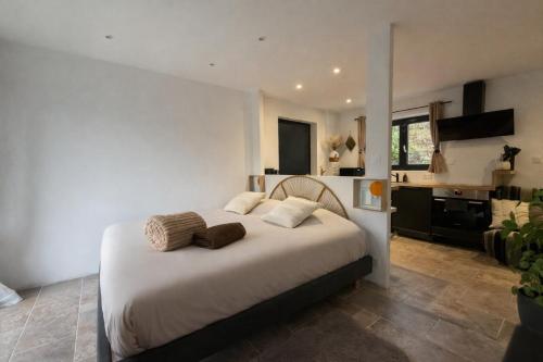 a bedroom with a large bed and a kitchen at Studio avec spa vue Moselle in Dinozé