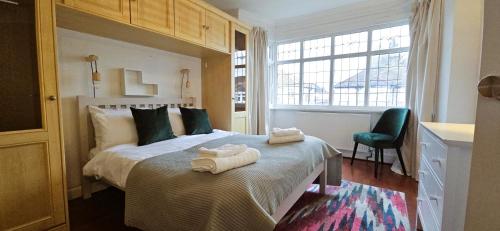 a bedroom with a bed with towels on it at Spacious Home Near Wembley, Free Parking, Close to Tube, Garden in Pinner
