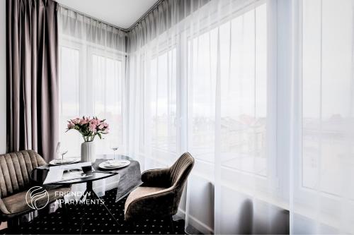 a dining room with a table and chairs and a window at SERENITY Aparthotels - Old Town Poznan by Friendly Apartments in Poznań