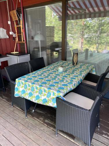 a table and chairs sitting on a porch with a table at Sunset Forest apartment in Joutsa