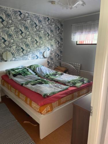 a bed in a small room with avertisementatronatronstrationstration at Sunset Forest apartment in Joutsa