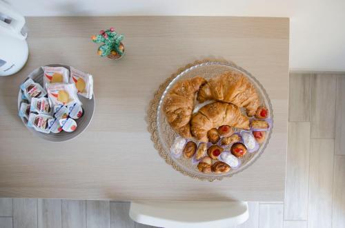 a table with a bowl of food and a plate of pastries at Residence La Perla - Marzamemi & Sea - Homie Livings in Marzamemi