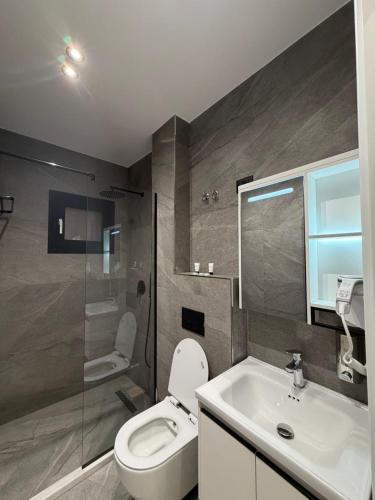 a bathroom with a toilet and a sink and a shower at Velour Boutique Hotel Durres in Durrës