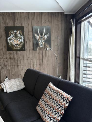 a living room with a couch and three pictures on the wall at Cozy Couples or Family Retreat - Hemsedal in Hemsedal