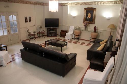 a living room with a couch and a tv at Hotel Sercotel Doña Carmela in Seville