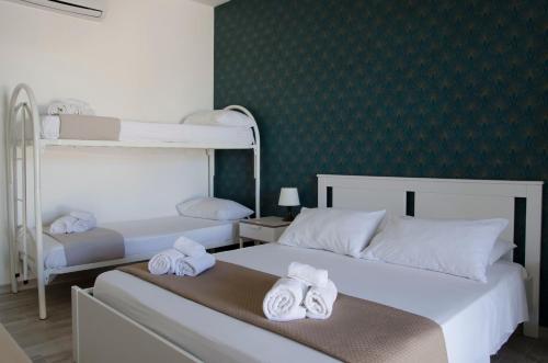 a bedroom with two bunk beds with towels at Residence La Perla - Marzamemi & Sea - Homie Livings in Marzamemi