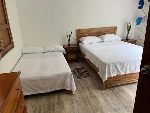 two beds in a room with at Cabane Finca la Gloria in San Vicente de Chucurí