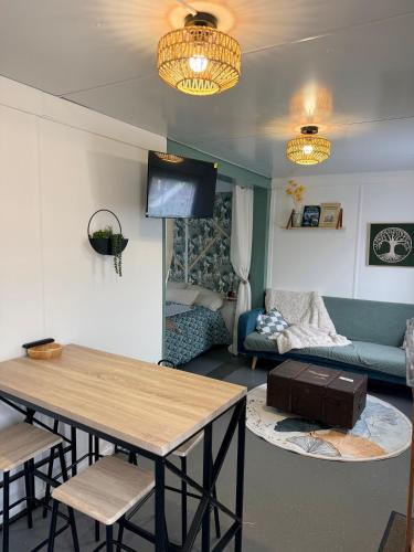 salon ze stołem i kanapą w obiekcie Le Petit Lodge w mieście Coulouvray-Boisbenâtre