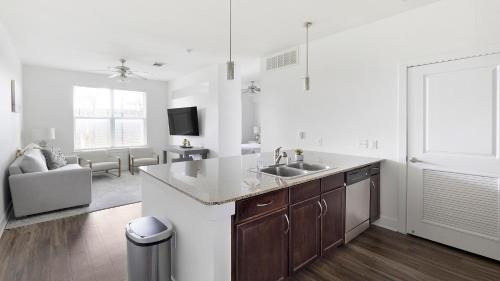 a kitchen with a sink and a living room at Landing Spectacular 1BD Clubhouse Gym in Charlotte