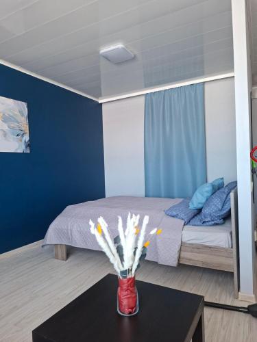 a bedroom with a bed and a table with flowers at Jelena Apartment 69 in Rēzekne