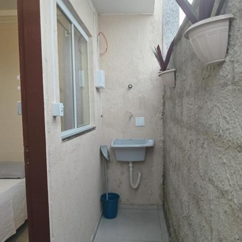 a small bathroom with a sink and a window at Loft Caminho de Búzios in Cabo Frio