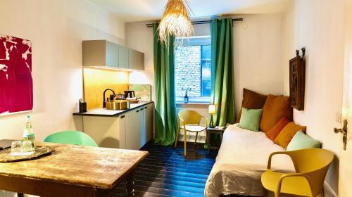 a room with a bed and a table and a kitchen at Schuhmacherei Rooms in Oestrich-Winkel