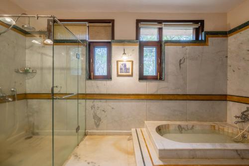 a bathroom with a tub and a glass shower at juSTa The Bagh, Kanha in Bhīmlāt