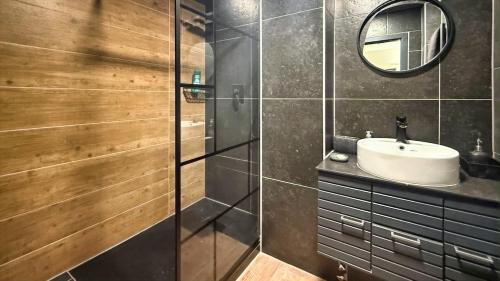 a bathroom with a shower with a sink and a mirror at Spacious 3-room apartment with balcony in Mönchengladbach