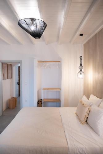 a bedroom with a large white bed and a lamp at Santa Maria Hotel in Elia Beach