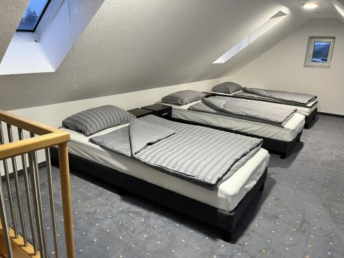 three beds in a room with a staircase at Sky Loft Schwarzach in Schwarzenbruck