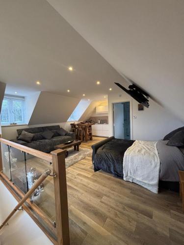 a attic bedroom with two beds and a couch at Tollgate Annexe in Ashford
