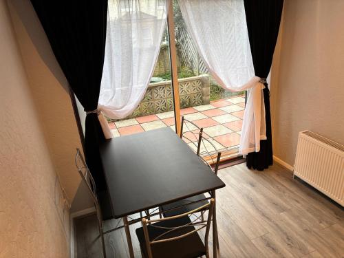 a table and chairs in a room with a window at Sea Rose Cottage, Broadstairs in Broadstairs
