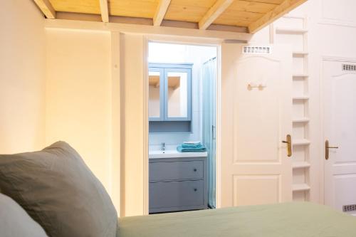 a bedroom with a bed with a sink and a mirror at La Calade Charming Apartment in Nîmes