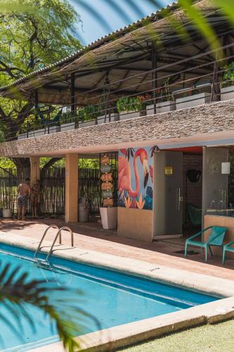 a pool with a painting on the side of a building at The Cantamar Beach Hostel in Santa Marta