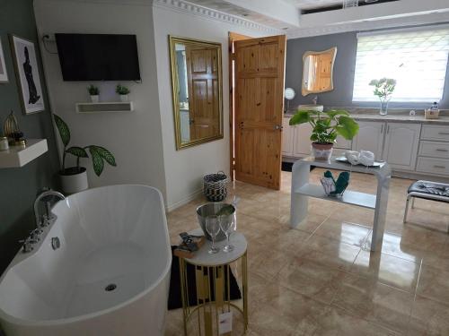 a bathroom with a white bath tub in a room at Dr Doc's Family Lodge with Pool in Spur Tree