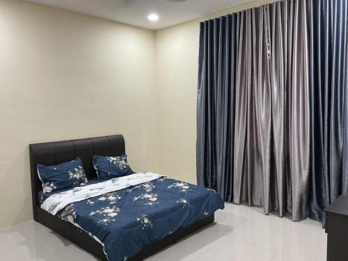 a bedroom with a bed with blue sheets and a window at HD DOUBLE-STORY House in Banting