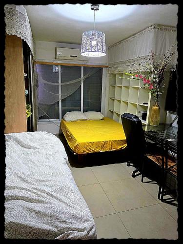 a bedroom with a yellow bed and a desk at Big Room Ashdod in Ashdod