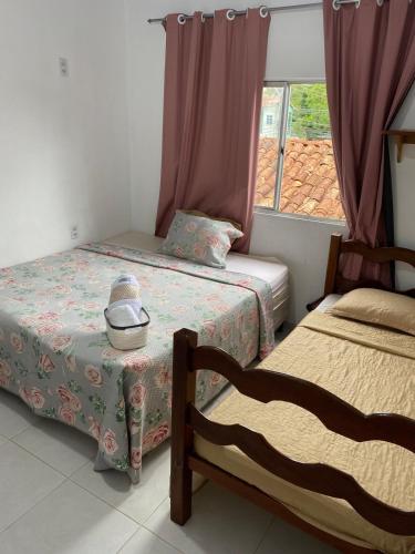 a bedroom with two beds and a window at Casa disponível para o carnaval in Belém