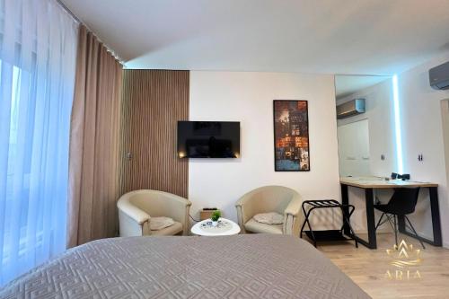 a bedroom with a bed and a table and chairs at ARIA Luxury Apartment, Tuzla in Tuzla