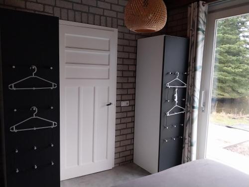 a bedroom with black and white closet and a door at Gastenverblijf De Lopende Eend in Boxtel