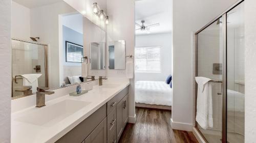 a white bathroom with a sink and a mirror at Landing Incredible 2BD Gym in Phoenix