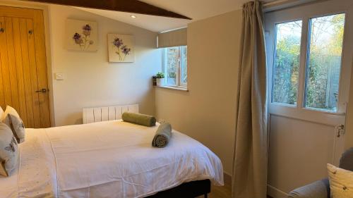 a bedroom with a white bed and a window at The Hive in Bream