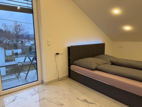 a bedroom with a bed next to a sliding glass door at Alea in Tuttlingen